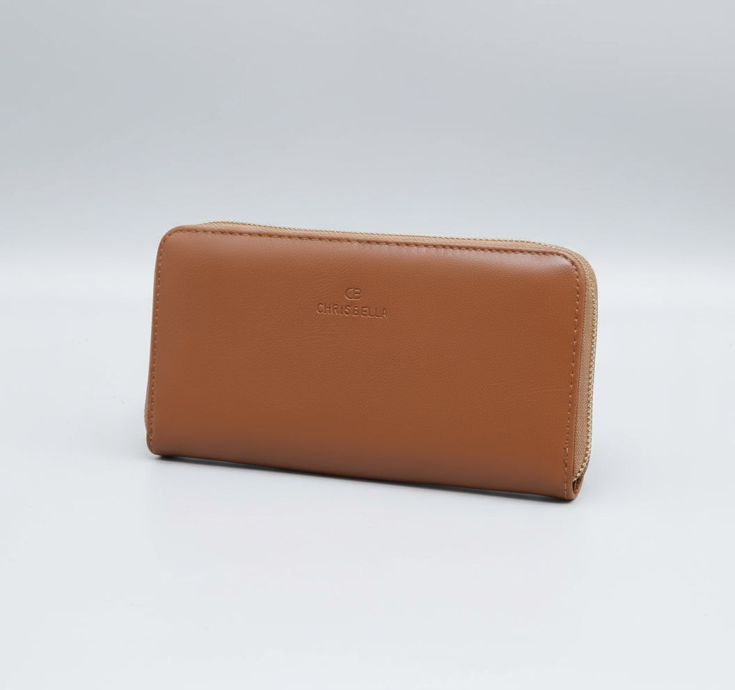 Brown wallet held by a hand on a green grass background